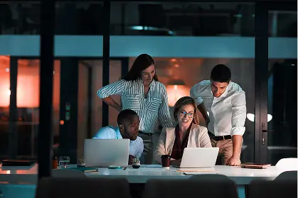 Team of professionals collaborating on laptops